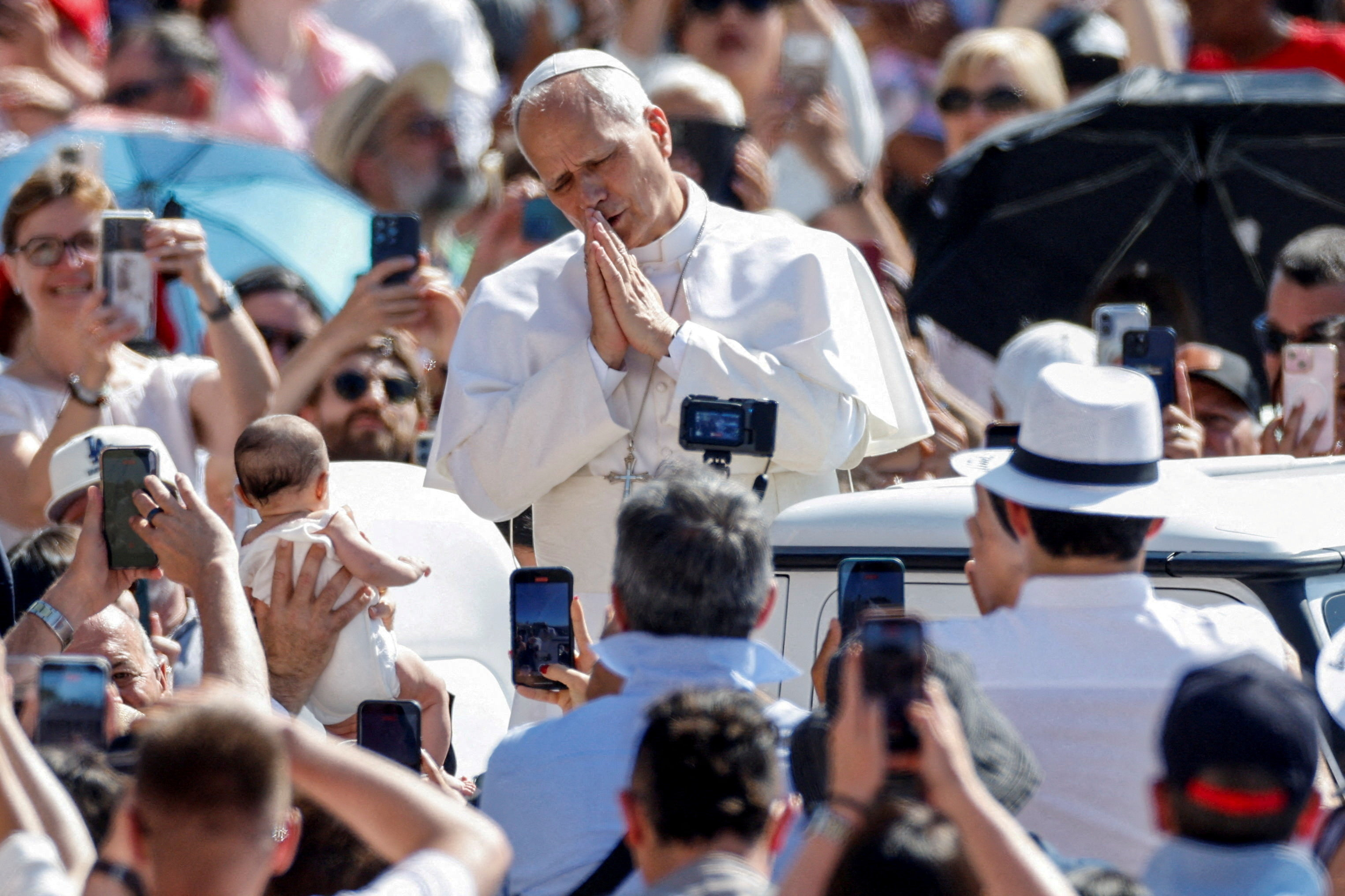 Il Papa benedice un neonato durante il giro in papamobile prima dell'udienza generale, 17 giugno 2026 - (Reuters)