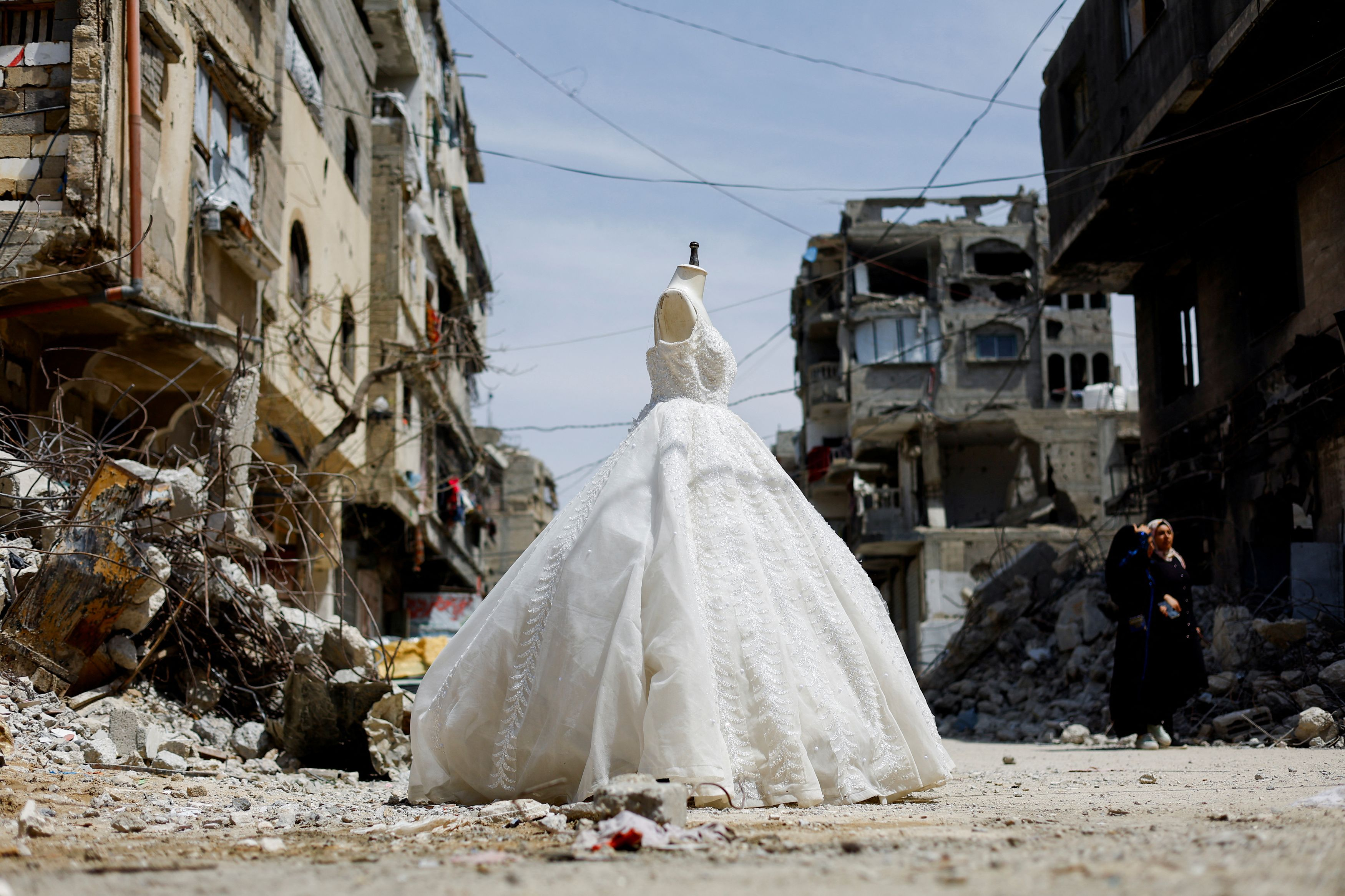 Un abito da sposa esposto fuori da un negozio a Gaza, tra le macerie / Reuters / Mahmoud Issa