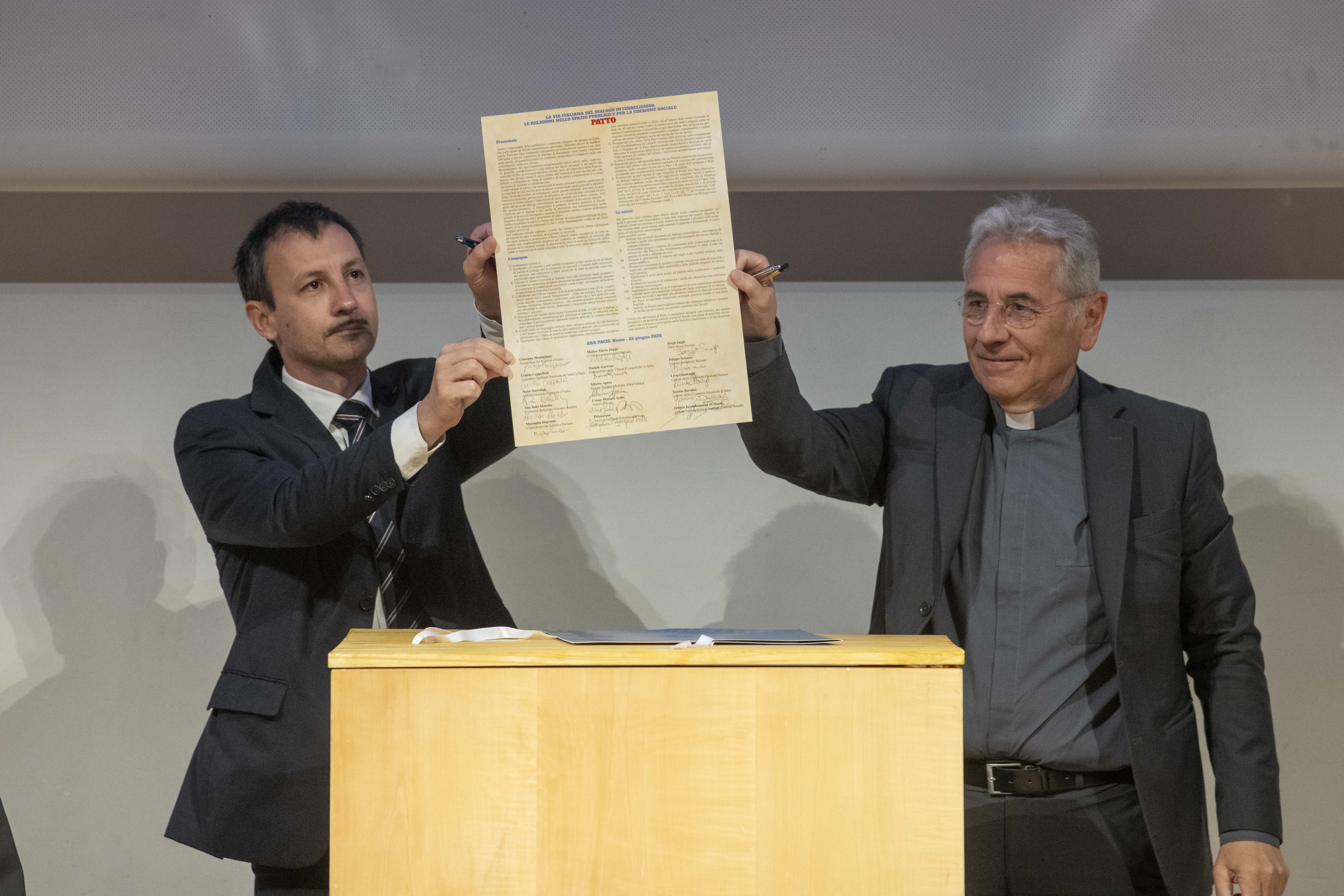 Don Giuliano Savina, direttore dell'Ufficio nazionale per l'ecumenismo e il dialogo interreligioso della Cei, mostra il Patto per il dialogo firmato dai leader delle religioni all'Ara Pacis, 25 giugno 2026 - (Siciliani)